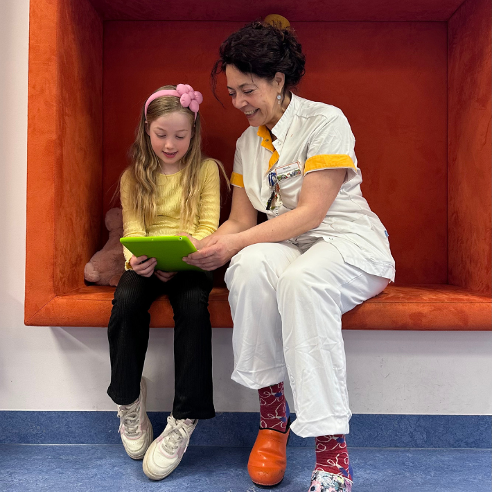 Kindervpleegkundige Nicole Donkel kijkt met een kind naar een tablet. Kindervpleegkundige Nicole Donkel kijkt met een kind naar een tablet.